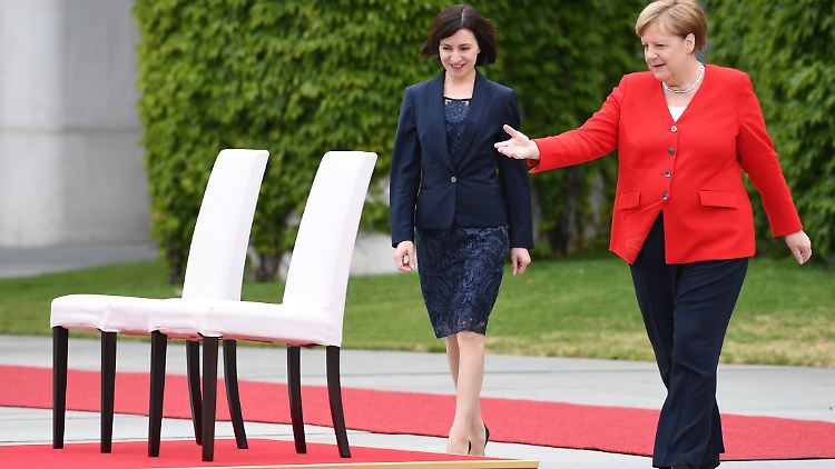 Die beiden Regierungschefinnen machen keine große Sache daraus, dass sie während des Empfangs nicht stehen.