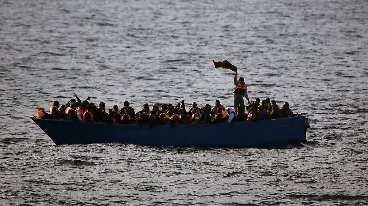 Flüchtlinge aus Afrika rufen auf dem Mittelmeer in einem Boot um Hilfe
