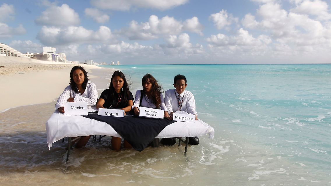 Das Wasser steigt - Klimaschützer am Strand von Cancún.