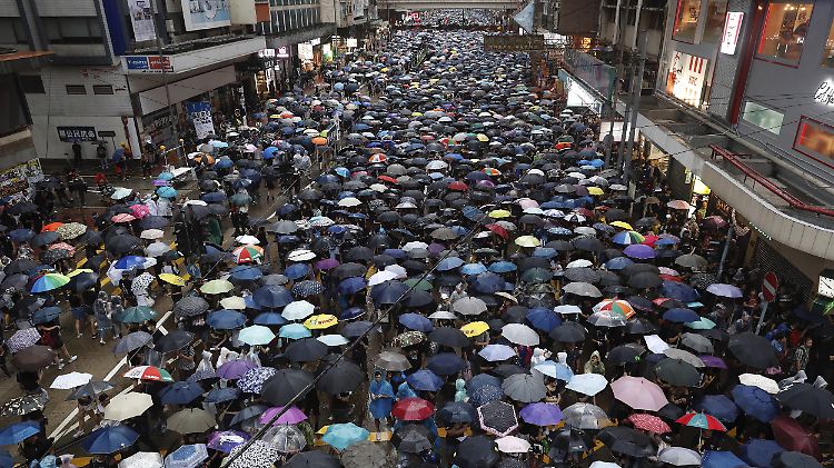 Unter Regenschirmen trotzen Hunderttausende dem schlechten Wetter - und der Führung der Volksrepublik.