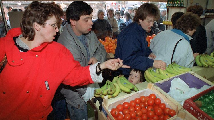 DDR-Besucher interessieren sich am 10.11.1989 in einem Geschäft in Herleshausen für Obst und Gemüse.