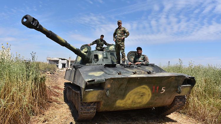 Syrische Soldaten sitzen und stehen auf einem Panzer. Der Bürgerkrieg im Land ist ein Grund für den Verfall der Währung.