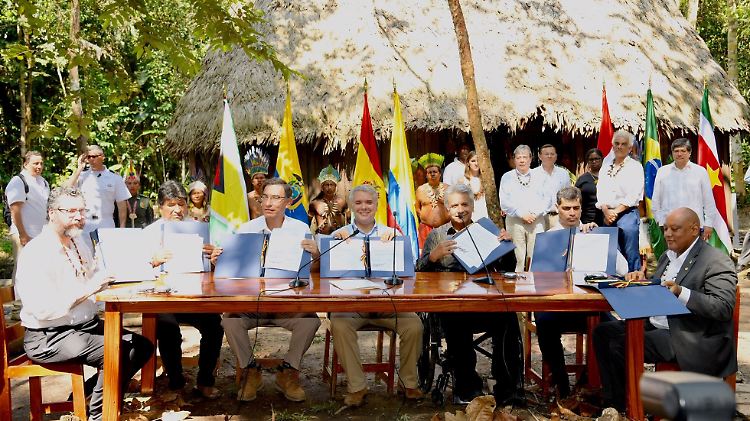 Sondergipfel vor Ort: Brasiliens Außenminister Ernesto Araujo, Evo Morales, Präsident von Bolivien, Martin Vizcarra, Präsident von Peru, Ivan Duque, Präsident von Kolumbien, Lenin Moreno, Präsident von Ecuador, Ashwin Adhin, Vizepräsident von Surinam, und Raphael Trotman, Minister für Naturressourcen von Guayana zeigen das unterzeichnete Abkommen am Tisch in Leticia. 