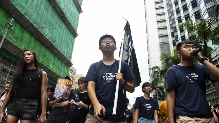 Der Hongkonger Aktivist Joshua Wong (Mitte) unterstellt der Kanzlerin Wirtschaftsinteressen vor demokratische Werte zu stellen.