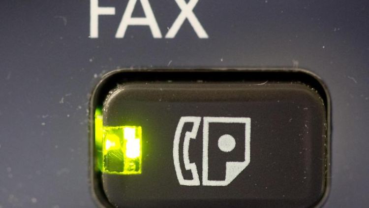 Das Licht an dem Knopf eines Fax-Gerätes leuchtet. Foto: Kay Nietfeld/Archivbild