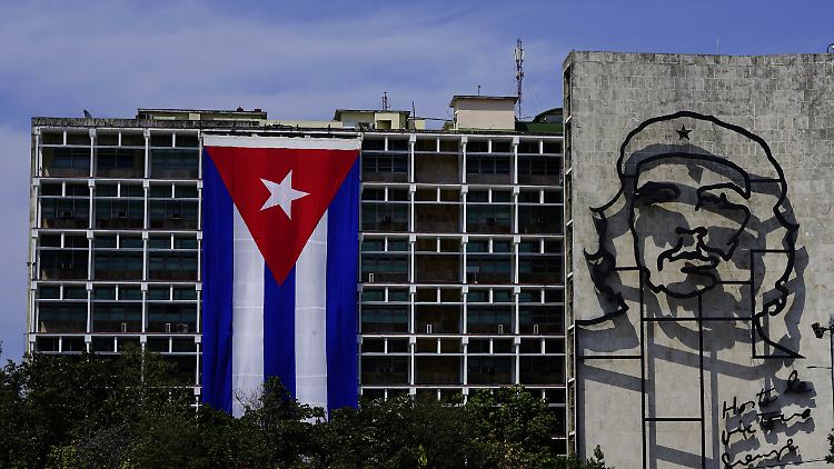 Eine riesige kubanische Fahne hängt neben dem Bild des Revolutionärs Che Guevara am Innenministerium im Zentrum von Havanna.