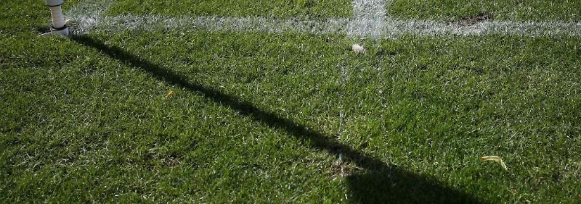 Der Schatten einer Eckfahne wird auf das Spielfeld geworfen. Foto: Friso Gentsch/Archivbild