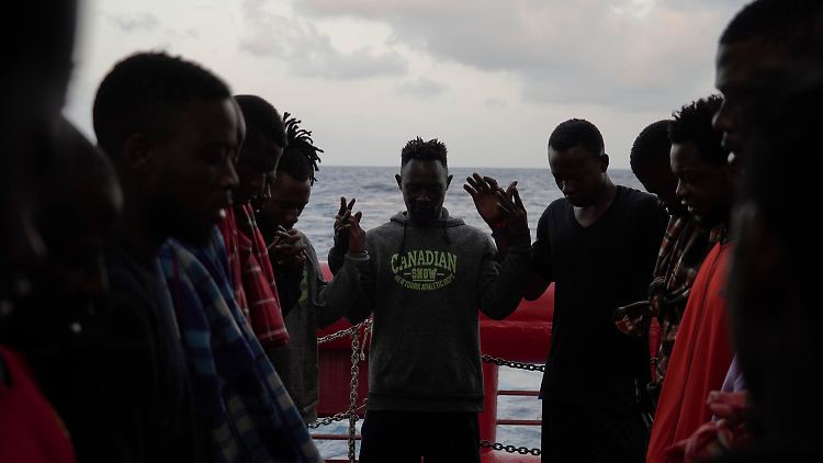 Migranten beten während des Sonnenaufgangs an Deck des Rettungsschiffes "Ocean Viking".