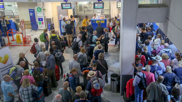 Touristen warten vor einem Thomas-Cook-Schalter in Heraklion auf Kreta.