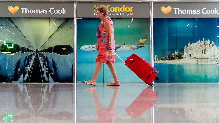 Eine Passagierin geht mit ihrem Koffer an einem geschlossenen Büro des insolventen Reisekonzerns Thomas Cook vorbei.