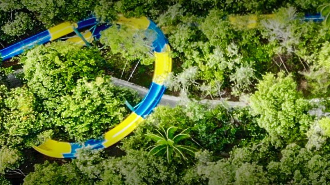 Die Wasserrutsche schlängelt sich durch eine Dschungellandschaft,