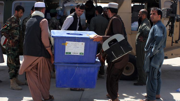 Mitarbeiter der afghanischen Wahlkommission tragen Wahlurnen.