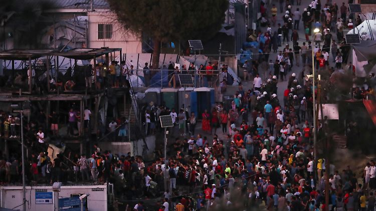 Flüchtlinge versammeln sich um die verbrannten Container in dem Flüchtlingslager Moria auf Lesbos. 