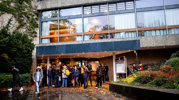 Journalisten und Zuschauer stehen vor der Stadthalle. Der Andrang hält sich aber in Grenzen.