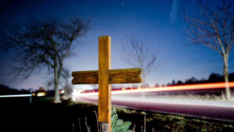 Ein Kreuz zur Erinnerung an einen Verkehrstoten steht an einer Landstraße.