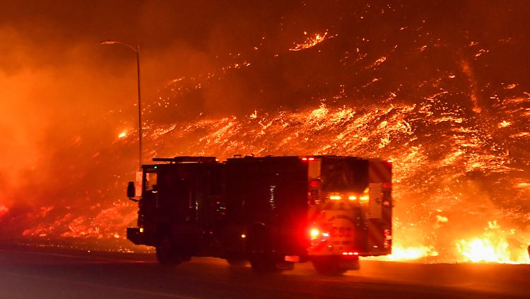 Die Feuerwehrleute versuchen, gegen das Feuer anzukommen. Mehrere Autobahnen und Straße wurden gesperrt.