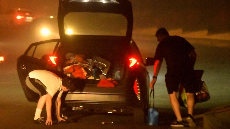 Anwohner packen ihr Auto, um dem Feuer zu entkommen. Mehrere Tausend Menschen wurden aufgefordert, die gefährdeten Gebiete zu verlassen.