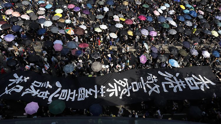 Mit großen Bannern und Regenschirmen sind die Hongkonger erneut auf die Straßen gezogen.