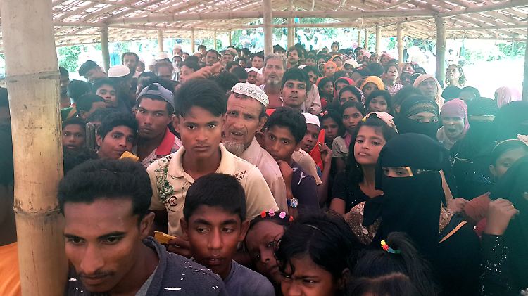 Angehörige der Rohingya stehen in einem Flüchtlingslager Schlange für Brennstäbe zum Kochen.