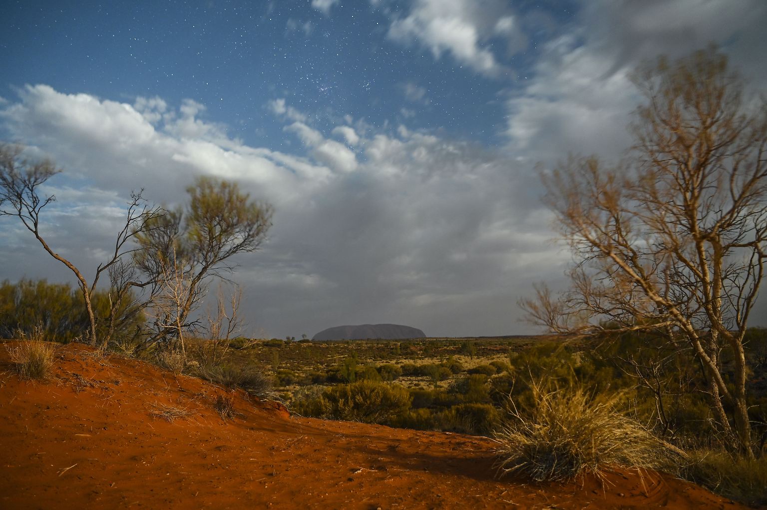 Von Weitem sieht der Uluru, der heilige Berg der Aborigines, wie ein Ort der Ruhe und Abgeschiedenheit im australischen Outback aus. 