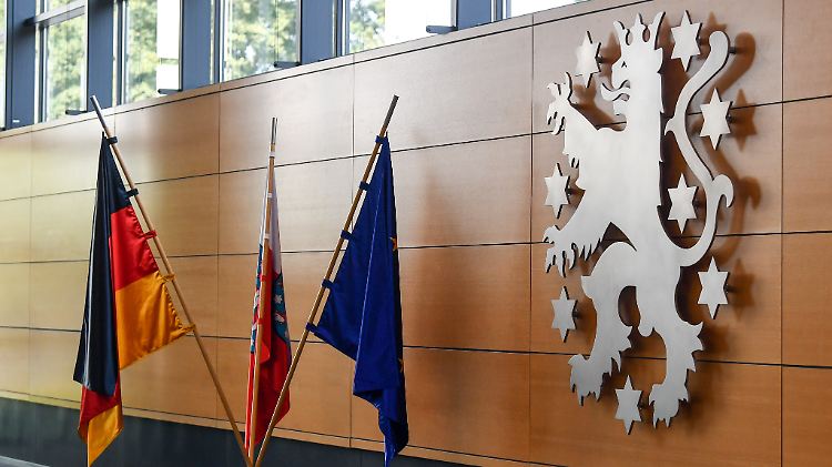 Blick in den Erfurter Landtag: Die Deutschlandflagge, die Flagge der EU und die Thüringer Landesfarben leuchten neben dem Wappen des Freistaats.