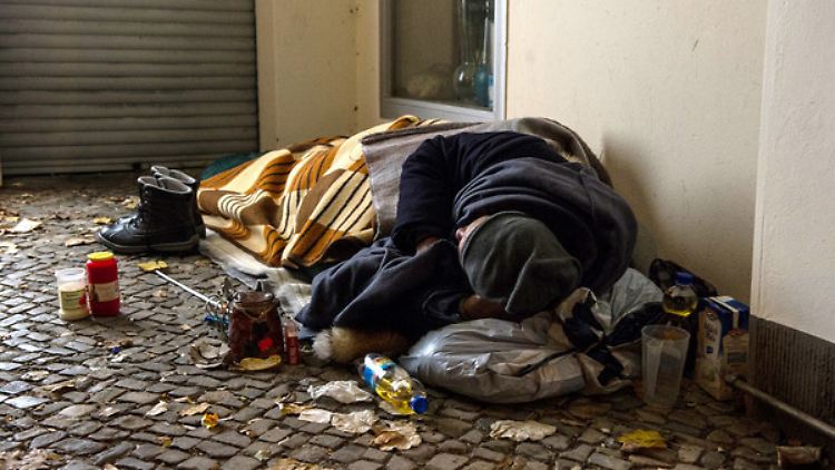 Ein Obdachloser liegt im Eingang eines Hauses in Berlin.