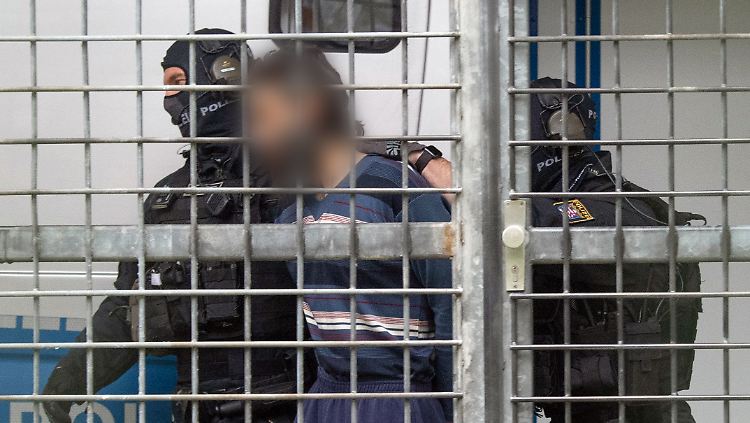 Vermummte Beamte einer Spezialeinheit der Polizei bringen einen terrorverdächtigen Mann zur Haftvorführung am Gericht.