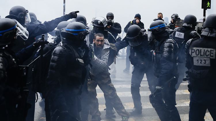 Ein Demonstrant wird von französischen Polizisten während einer Demonstration der Gelbwesten festgehalten.