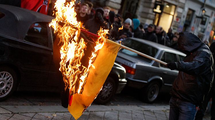 Im Hamburger Karoviertel wird am Rande der Demonstration eine Deutschland-Fahne angezündet.