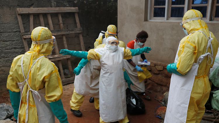 Während der Beerdigung einer Person, die vermutlich an der Krankheit verstorben ist, desinfizieren Ebola-Helfer ihre Utensilien. 