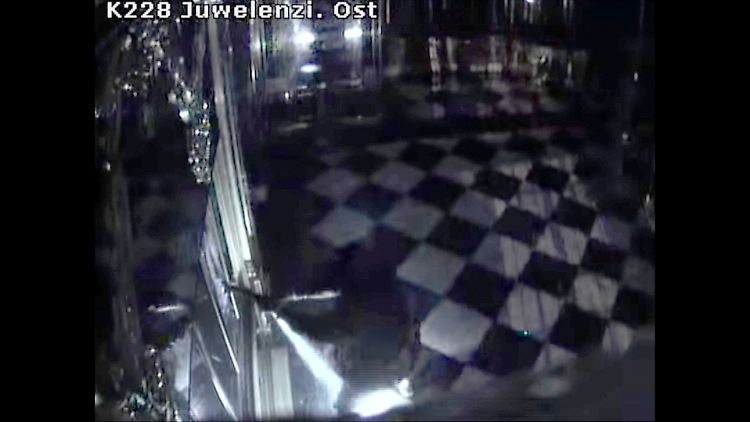 Ein Bild aus der Überwachungskamera zeigt, wie einer der Täter die Vitrine zerstört.