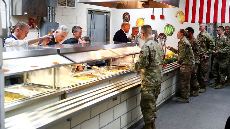Den mitreisenden Journalisten zufolge dankte Trump den Truppen für ihre Einsatz und servierte ihnen Truthahn - das traditionelle Essen an Thanksgiving.