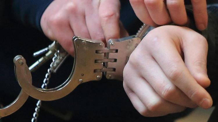 Handschellen werden einem Mann angelegt.