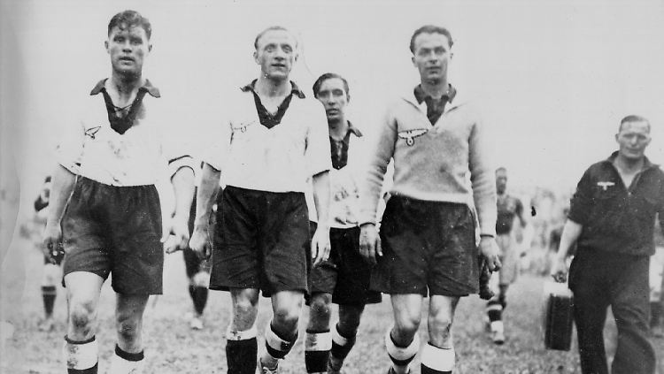 Weltmeisterschaft 1934 in Italien: Paul Zielinski, Fritz Szepan, Willy Busch und Torhüter Willibald Kress verlassen abgekämpft, aber zufrieden das Stadion in Mailand. Die deutsche Fußballnationalmannschaft hat just am 31. Mai das Zwischenrundenspiel gegen Schweden mit 2:1 gewonnen.
