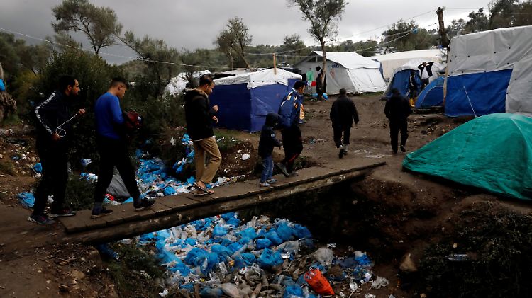 Flüchtlinge auf Lesbos überqueren einen Kanal aus Müll.