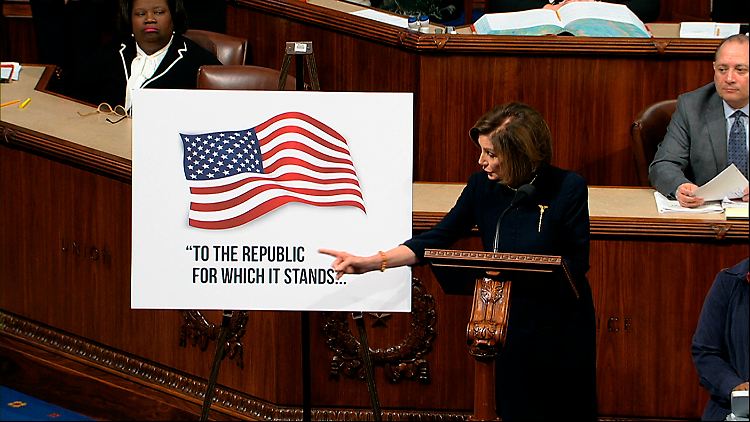 Nancy Pelosi zeigt während einer Rede auf ein Plakat mit einem Ausschnitt des Treueschwurs "To the republic for which it stands" (für die Republik, für die sie steht).
