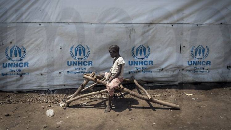 Ein Flüchtling vor einem Zelt des UNHCR in Uganda.