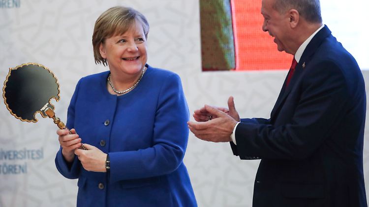 Ein Spiegel für die Bundeskanzlerin - Angela Merkel hebt das verzierte Schmuckstück aus dem Kasten, schaut hinein und lächelt dann den türkischen Präsidenten Recep Tayyip Erdogan an
