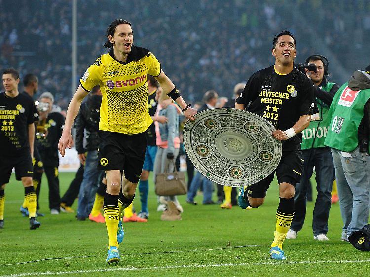 Links Neven Subotic, rechts Lucas Barrios, in der Mitte die (nicht echte) Meisterschale.