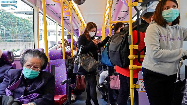 In einem Bus in Hongkong tragen die Menschen Mundschutz.