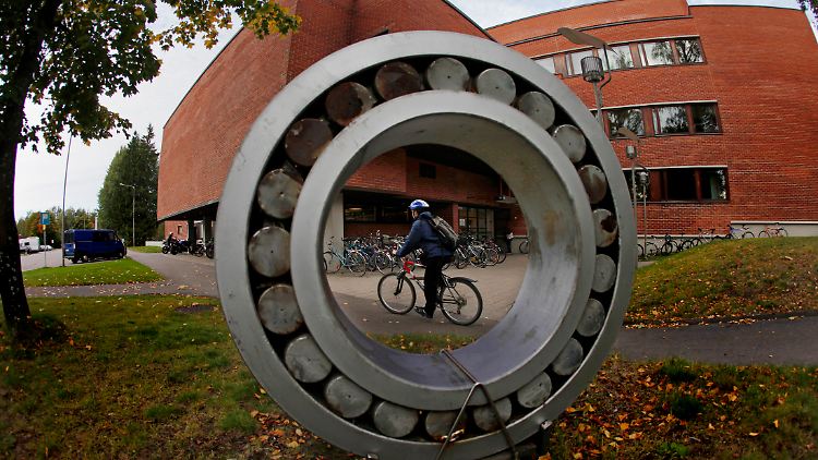 Ein Radfahrer fährt an einem Institut der Aaalto-Universität in Helsinki vorbei.
