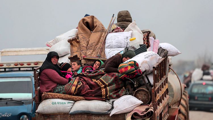 Eine Familie flüchtet beladen mit ihrem Hab und Gut aus der Region Idlib.