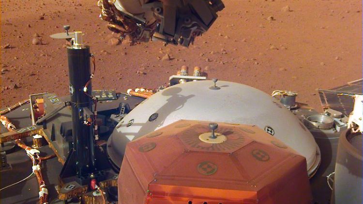Raumsonde "InSight" auf dem Mars: Gut zu erkennen sind ihre Instrumente. Die Aufnahme stammt von einer Kamera am Roboterarm der Sonde. 