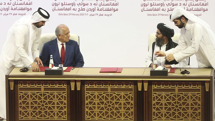 Zalmay Khalilzad (2.v.l), US-Sondergesandter für Aussöhnung in Afghanistan, und Mullah Abdul Ghani Baradar (2.v.r), Leiter des politischen Büros der Taliban, unterzeichnen in Doha das Abkommen.