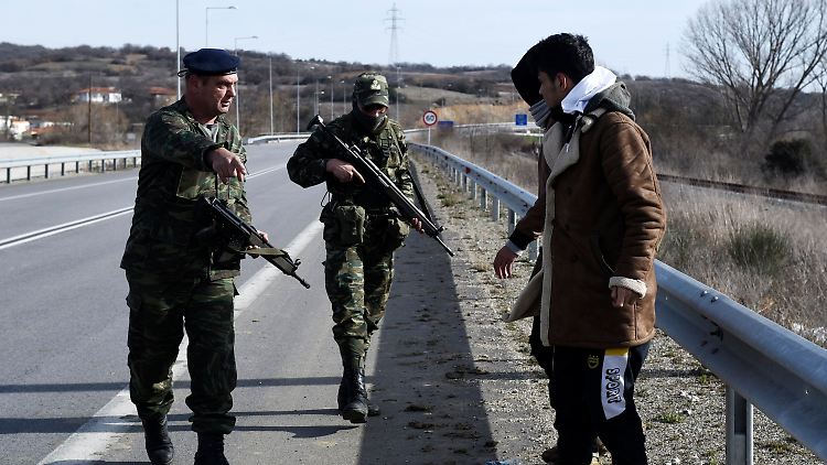 Griechische Soldaten und Migranten an der Grenze zur Türkei.