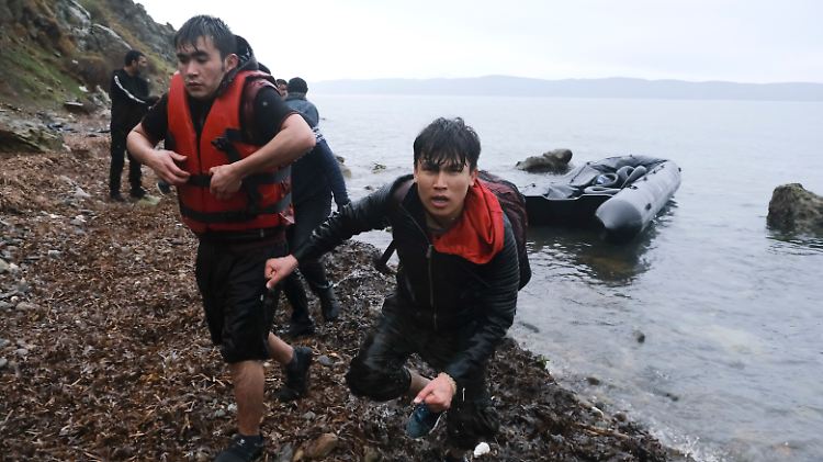 Migranten aus der Türkei erreichen mit einem Schlauchboot die griechische Insel Lesbos. Ein anderes Boot wird am Anlegen gehindert.