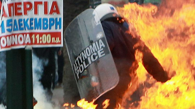Polizisten werden mit Brandsätzen beworfen.