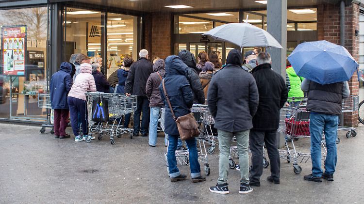 Menschen stehen Schlange: Sie wollen bei Aldi Desinfektionsmittel kaufen.