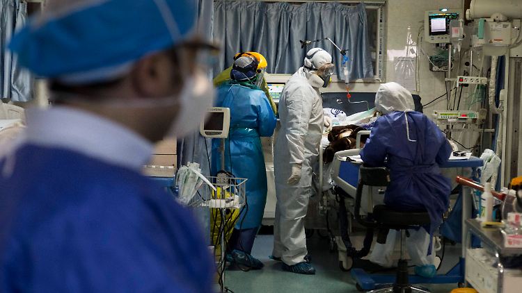 Medizinisches Personal betreut im chinesischen einen Patienten in kritischem Zustand.