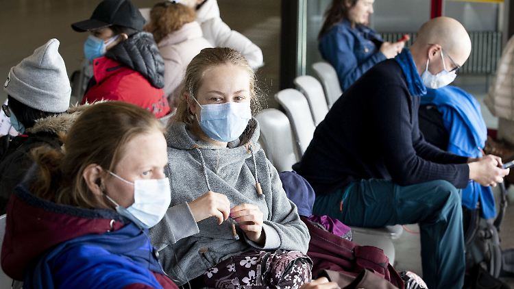 Menschen mit Schutzmasken am Flughafen Berlin-Tegel.